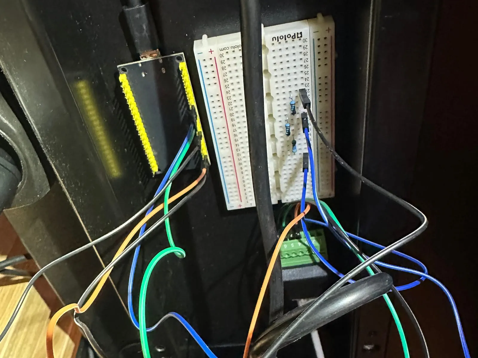 The ESP32, the breadboard and the RJ45 terminal mounted under the desk, with wires hanging below